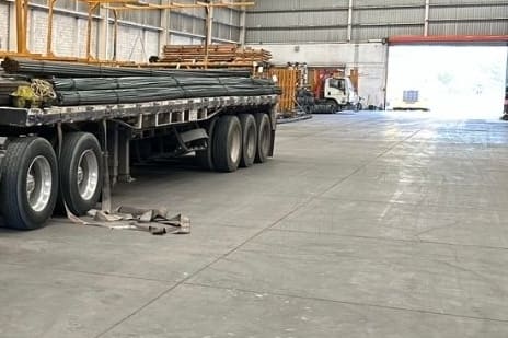 Plataforma cargada con varilla de acero dentro de una nave industrial.